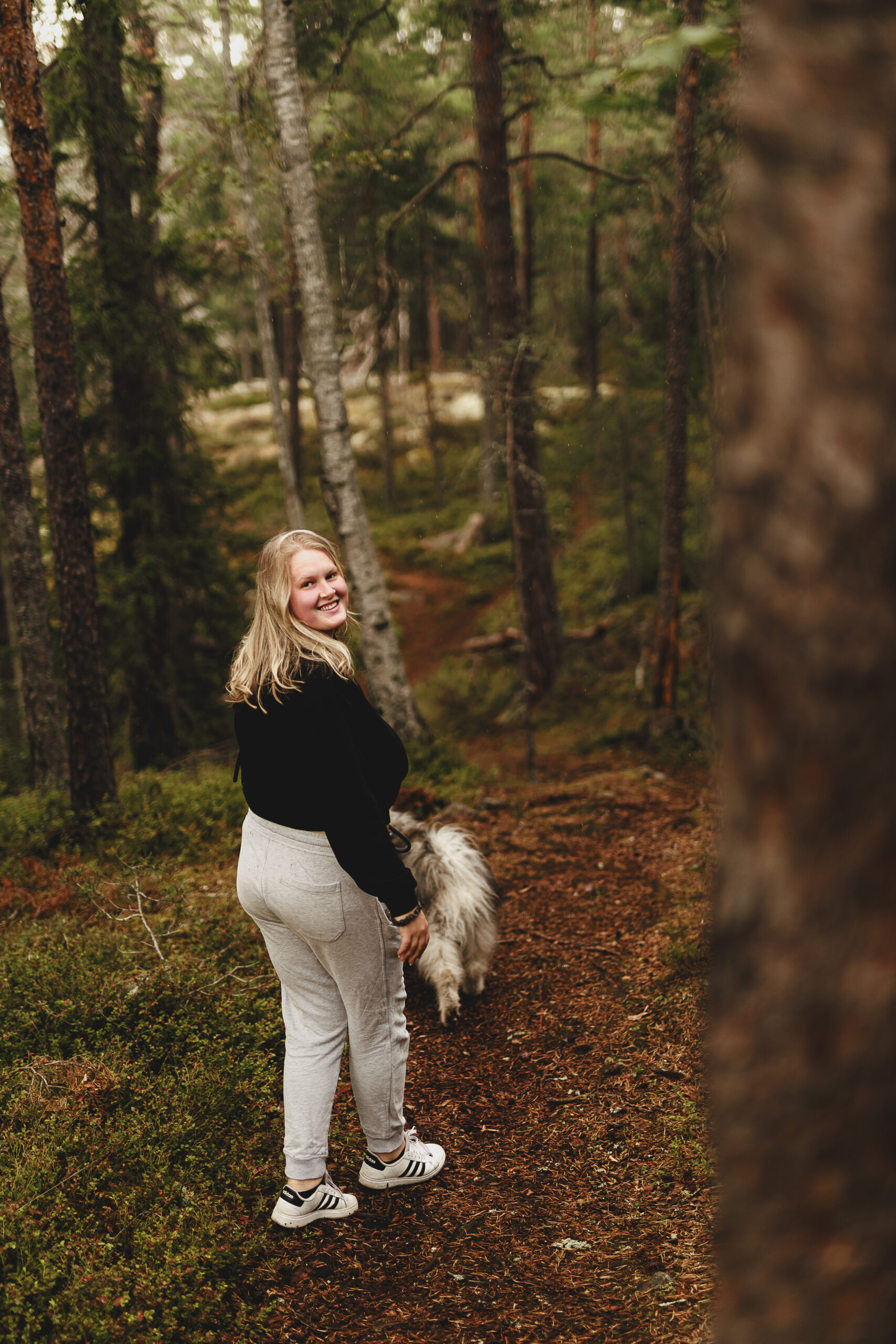 Fotograf Fia Wolle ute och går i skogen med hund